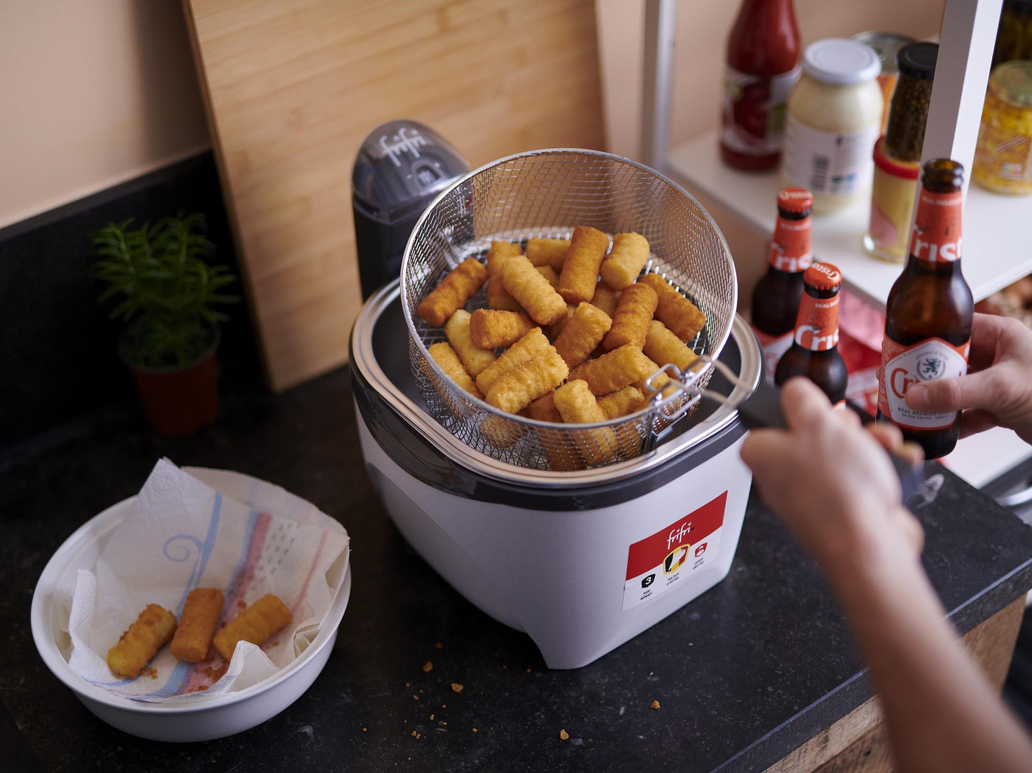 Friteuse avec croquettes, bouteilles de bière.