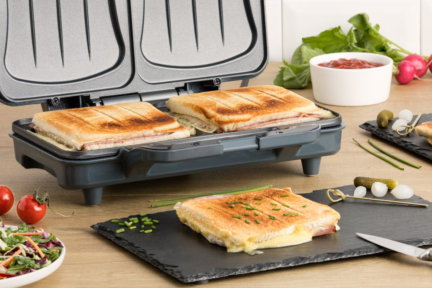 Appareil à panini gris avec paninis grillés.