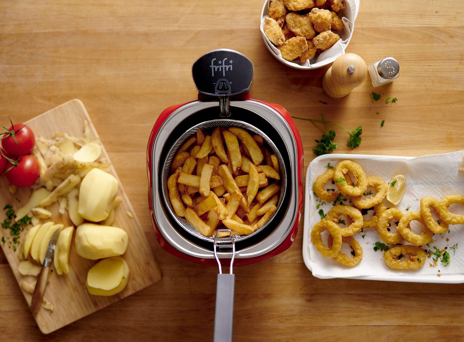 Friteuse rouge avec frites, calamars frits et poulet frit.