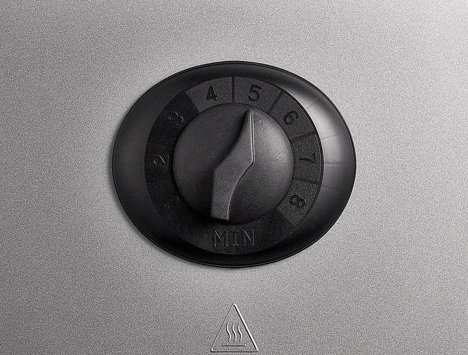 Un cadran noir numéroté de 1 à 8 est réglé sur 5, monté sur une surface métallique grise, avec un symbole d'avertissement de vapeur en dessous.