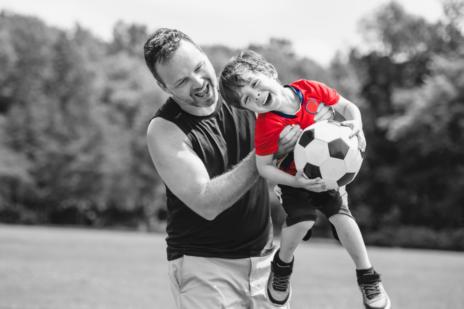 Young soccer player having fun on a field with his father